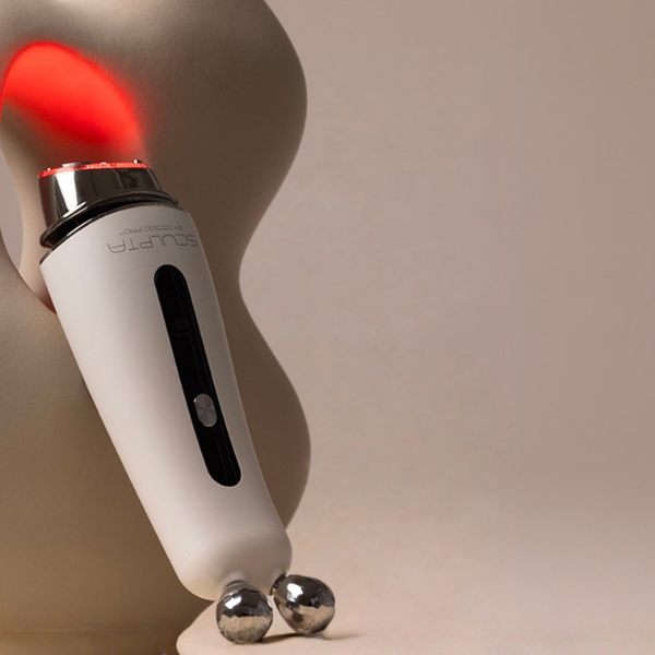 Sculpta by Déesse PRO with a red LED glow against a sculptural form