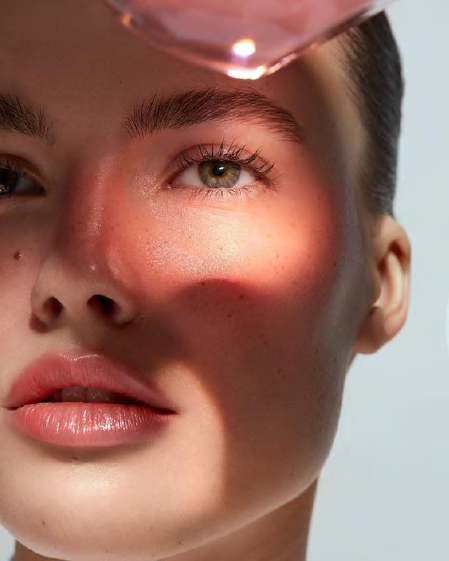 Close-up of a woman's face with light and shadow patterns highlighting natural skin texture